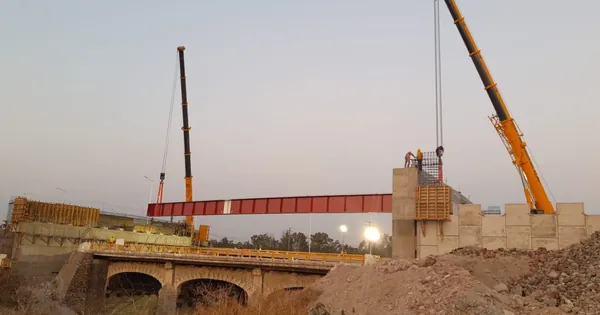 Dos grúas colocando en tándem una trabe de acero