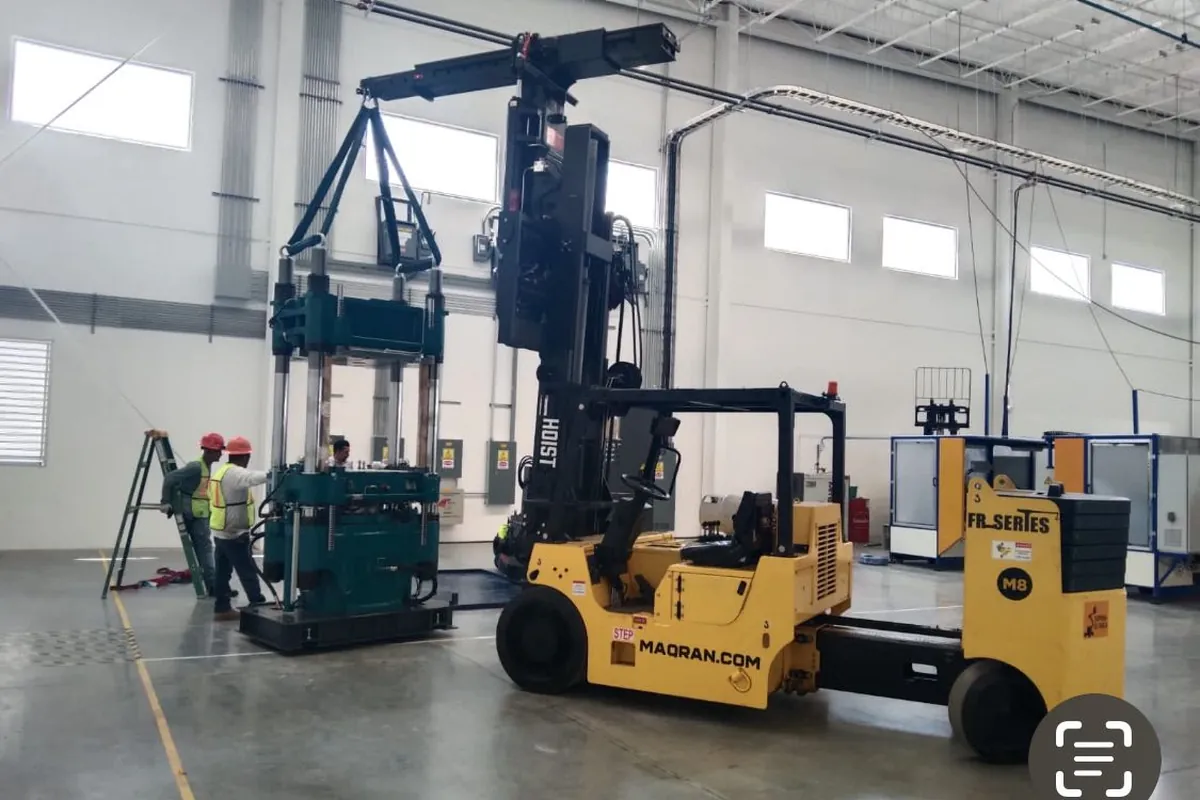 Versa-Lift colocando una prensa hidráulica dentro de una nave industrial